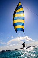 Tourist enjoying his ride on a kind of kite with seat over the turquoise sea near Cancun, Mexico.