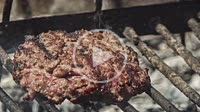 Detail of Hamburger on the grill with smoke and steam