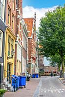 Netherlands. Summer street of Amsterdam. Typical house with a sloping facade among others.