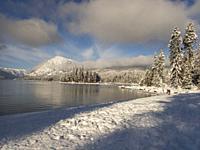 View of the shoreline and the snow-covered forest at Lake Wenatchee State Park in eastern Washington State, USA.