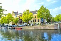 Netherlands. Spring day on the Amsterdam Canal. Boats moored on the water and cars on the embankment.