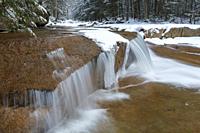 Cascade along the Pemigewasset River near the Flume Visitor Center in Franconia Notch State Park in Lincoln, New Hampshire during the winter season.