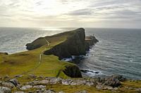 Neist Point Lighthouse, big cliff, cloudy day, sun rays, Skye Island, Highlands, Scotland.