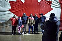 A group of six people pose in front of a large Canadian flag on the side of a semi-trailer truck on 11 February 2022 in Windsor, Ontario on day five o...