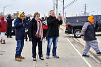 Three people look at a police barrier on College Street on 12 February in Windsor, Ontario on day six of the Freedom Convoy blockade of the Ambassador...