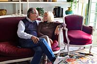 Happy mature couple. Sitting on an elegant sofa and intimate atmosphere.