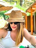 Young girl outdoors with straw hat and sunglasses