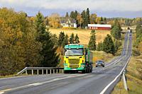 Yellow and green Scania R500 truck of Siuntion Koneasema Oy in seasonal sugar beet haul on scenic autumnal road in Salo, Finland. October 12, 2019.