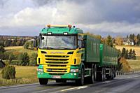 Yellow and green Scania R500 truck of Siuntion Koneasema Oy in seasonal sugar beet haul on scenic autumnal road in Salo, Finland. October 12, 2019.