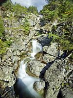 Huge waterfall of Sant Espirit flowing towards Estany Llebreta lake. Summer time at Aiguestortes National Park. Lleida province, Catalonia, Spain.