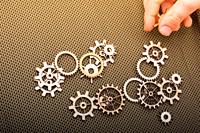 Hand holding gear wheels as the concept of mechanism.
