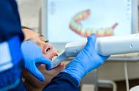 Great concept of dental procedure, young blond Brazilian woman in the dental chair suffering dental procedure by dentist as use of visualization monit...