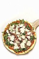 parma ham, rocket leaves and parmesan cheese gourmet pizza on white background.