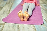 Close up of feet leg Little girl doing stretching exercises, practicing yoga on fitness mat at home, Playing sports, Healthy lifestyle. Kids sport hom...