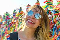 Girl in front of the grid with colored ribbons of Bonfim church in Salvador Bahia Brazil.