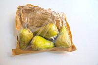 Four pears in a paper bag.
