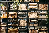 View of assortment of decor for interior shop in store of shopping center. View of shelving with pillows, plaid, towels. View of home accessories for ...