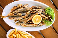 Dish Of Georgian National Cuisine: Mullet Fish With orange and french fries. fish and chips.