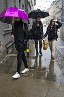 Riga, Latvia, Pedestrian women walking in the rain with umbrellas.
