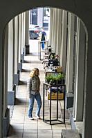 Riga, Latvia, A woman in alleyway walks by a flower shop.