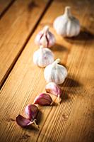 White raw garlic on wooden plank desk background. Organic garlic whole and cloves.