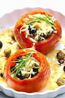 baking tomatoes filled with green and black olives and cheese.