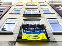 Berlin, Germany. Ukrainian Flag with: ""Stand with Ukraine"" on a Kreuzberg residential apartment building.