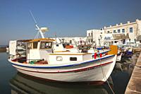 Traditional fishing boats in front of the whitewashed houses in Naoussa port, Paros, Cyclades Islands, Greek Islands, Greece, Europe.