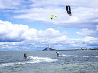 Kiteboarders or Kitesurfers in Tampa Bay with The Sunshine Skyway Bridge in the background in St Petersburg Florida USA.