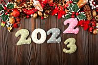 Colorful stitched digits 2022 of polkadot fabric with Christmas decorations flat lay background on wooden table.