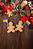 Christmas background of gingerbread cookie men with rainbow flags on wooden table.