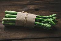 Fresh green asparagus sprouts on a wooden background. View from above.