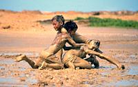 Boys are playing in the sand ( Guajira, Colombia). The action is taking place in the desert of Guajira after the rain.