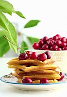 Stack of baked Belgian waffles with ripe red cherries on the white table, breakfast	.