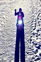 Inner-light selfie in fresh snow, Ontario, Canada. A long shadowy figure. Late afternoon. Self transfigured, planted on pristine nature. Symbolizes ha...