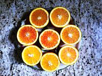 Juicy halves of four oranges arranged in a circle on an ornate platter. Design in eight perfect semi-circles.