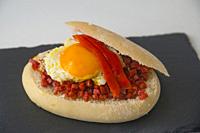 Tapa made of fried egg, picadillo and red pepper in bread. Spain.