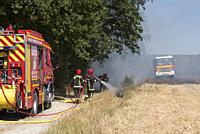 Firefighters extinguishing a stubble fire in a field already harvested, Eure-et-Loir department, Centre-Val-de-Loire region, France, Europe.