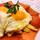 Fried egg with chips and Iberian ham. Spain.