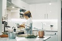 One woman cooking at home in the kitchen alone. Real single lifestyle for independent female people. Housewife preparing lunch for the family. View of...
