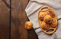 Baked round buns on a wooden table, top view.
