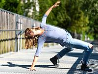 Athletic pose of an attractive 22 yo blonde girl on a pedestrian bridge, Belgium.