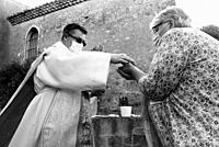 A priest offers a woman communion