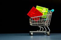 Cardboard boxes in a cart on a black background. online shopping or e-commerce concept.