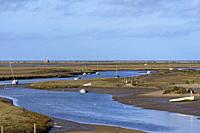 Marshes and river Glaven in Blakeney National Nature Reserve with Race Bank Wind Farm situated beyond the horizon in the Norh Sea, Norfolk, England.