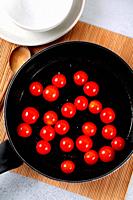 Skillet with hot cherry tomatoes.