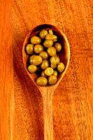 Close-up of wooden spoon with peas.