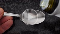Olive oil is poured into a spoon