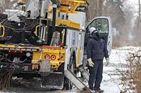 Detroit, Michigan, USA - 23 December 2022 - DTE Energy workers repair a power line taken down by a falling tree during a winter storm. The storm broug...