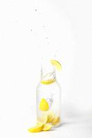 Glass of lemonade with splashing water on white background drink.